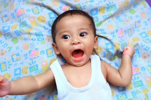 baby lying on blanket with mouth open baby lying on blanket with mouth open