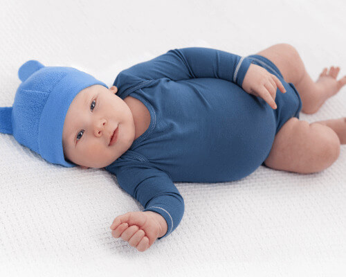 Baby boy wearing blue sleeper and hat