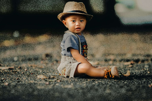 Baby boy sitting on the lawn.