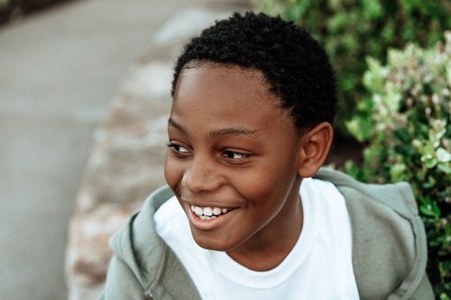 Boy smiling widely while outside.