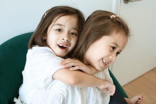 Child has her arms around moms neck.