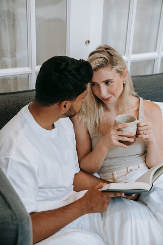 Couple drinking coffee and reading a book.