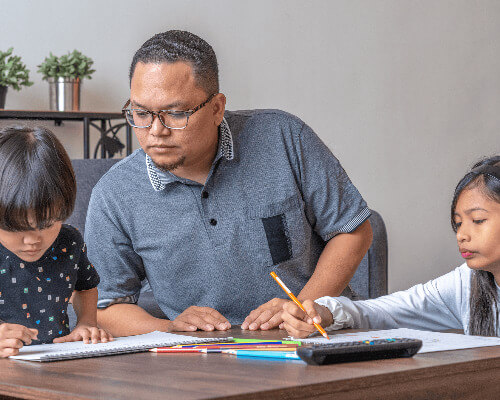 Dad helping kids with homework.