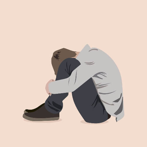 depressed boy hugging his knees