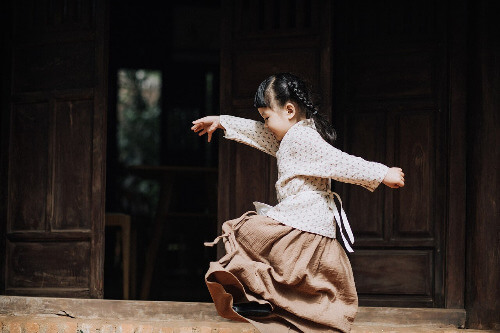 Young girl dancing outdoors.
