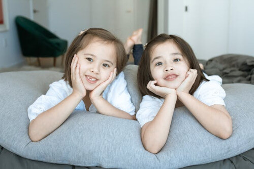 Girls with heads in hands while lyingon a large pillow