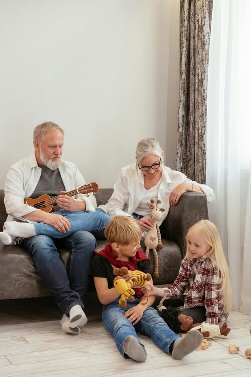 Grandparents on couch watching grandkids play