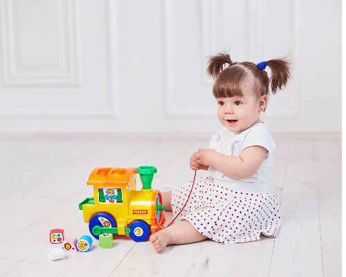 Little girl playing with train.