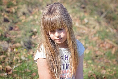 Low self-esteem girl standing in field.