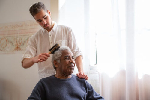 Man combing elders hair.
