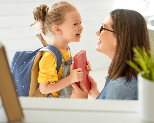 Mom and daughter holding a book and laughing