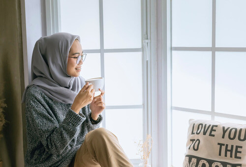 Enjoying a coffee sitting on window ledge.