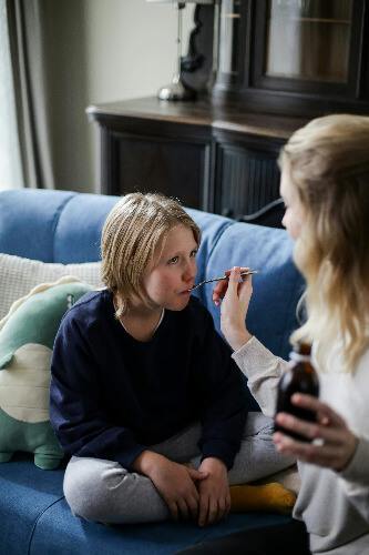 Mom giving meds to sick child
