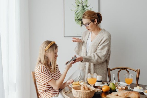 Mom removing phone from teen. 