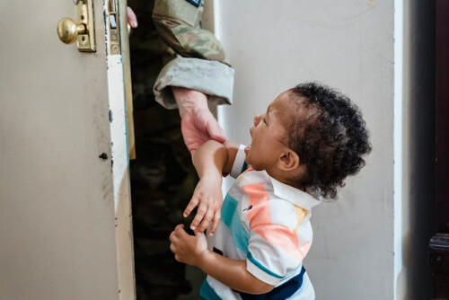Parent leaving out the door, child crying.