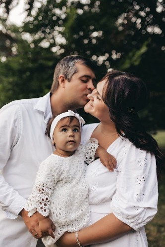 parents kissing with daughter