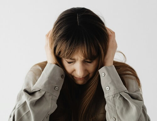 Woman covering her ears.