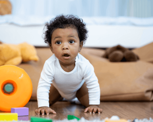 Baby boy crawling and playing with toys.