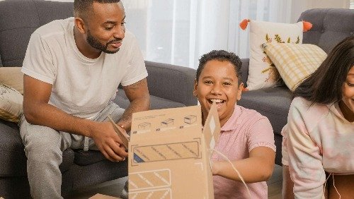 Boy opening a box and laughing.