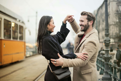Couple dancing by train. 