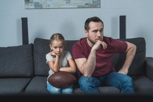 Dad and daughter watching football