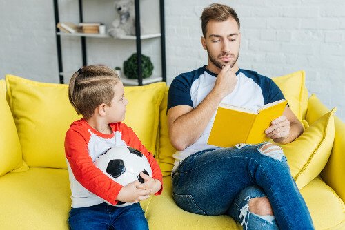 Dad sitting with son on the couch. 