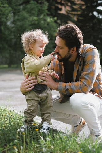 Dad at child's level discussing something. 