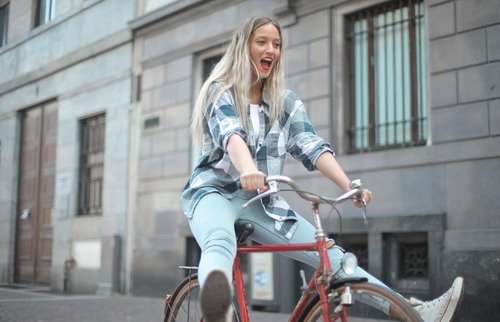 Woman with feet up on a bike.