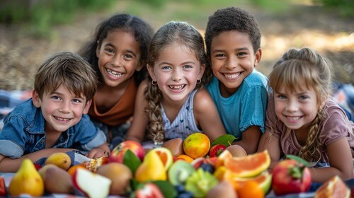Group of kids sitting in front of fruit