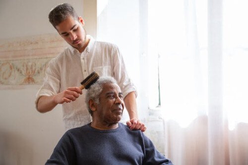 Man combing elders hair. Man combing elders hair.