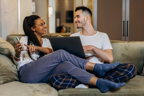 Man and woman on devices and laughing.