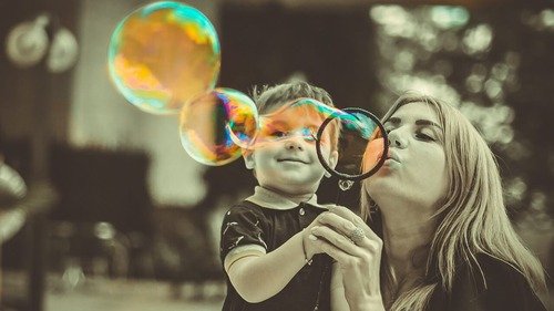 mom and child blowing bubbles