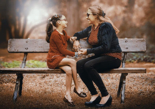 Mom and daughter sitting on a bench. Mom and daughter sitting on a bench.