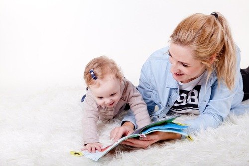 Mom reading a picture book to her baby.