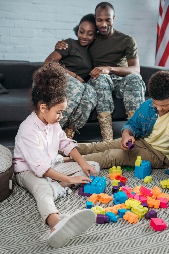 Sibling playing on floor while parents watch.