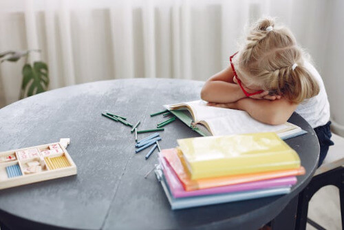 Young girl with head on table. 